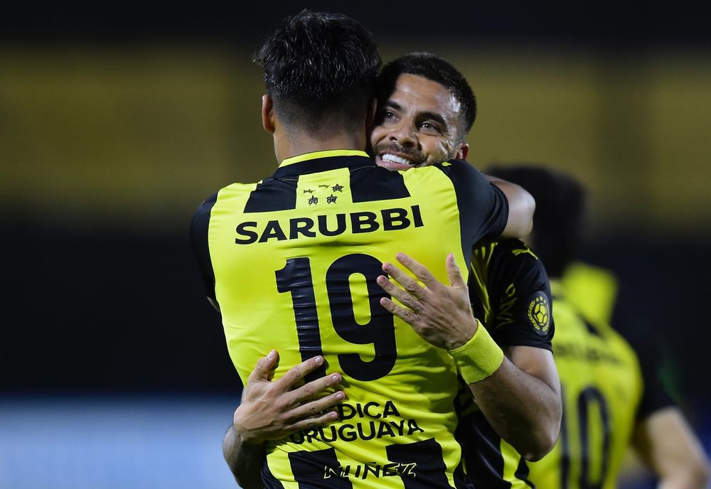 Los dos goleadores de la noche de Peñarol ante Danubio por el Torneo Clausura: Matías Arezo se abraza con Héctor Villalba