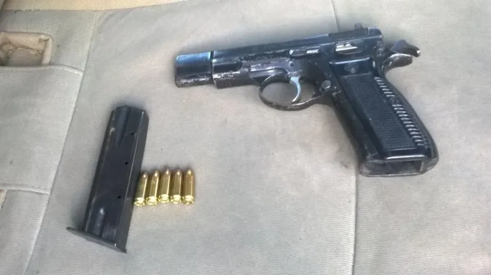 La Policía incautó este domingo esta pistola, con el cargador y cinco balas entre las banderas de Peñarol