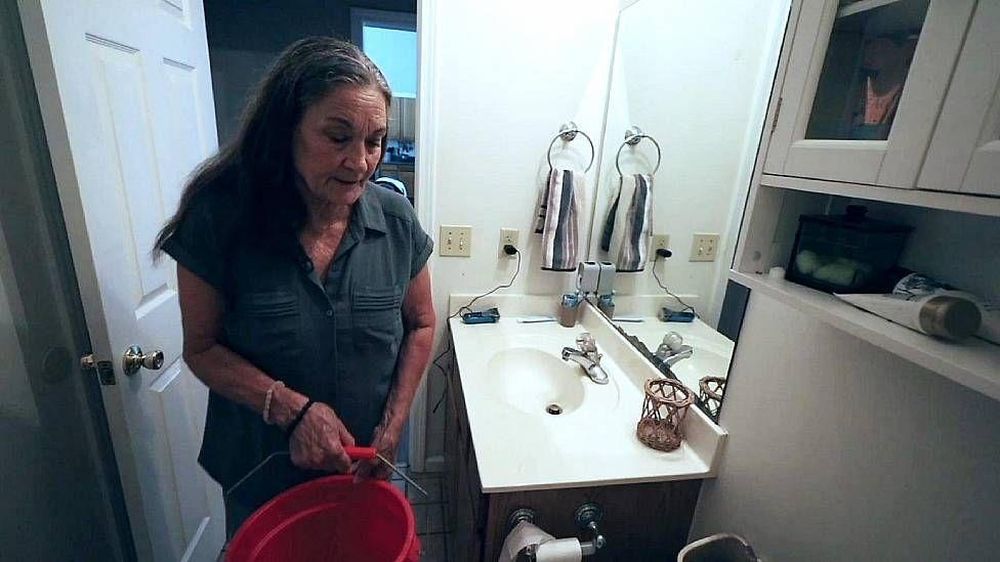 Beverly Morris tiene que llenar baldes para el inodoro debido a la baja presión del agua.