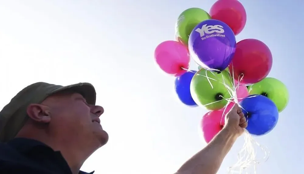 Escocia. Un partidario del Sí a la escisión de Escocia del Reino Unido suelta globos durante el acto de campaña