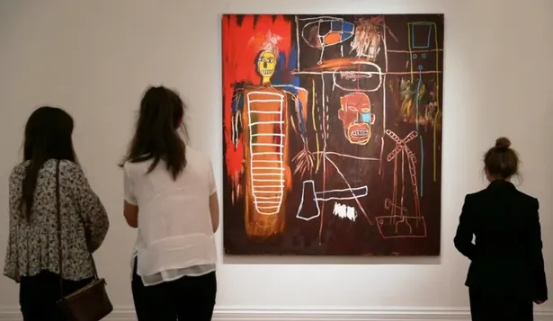 El público observando una de las obras de arte en exhibición que pertenecieron a David Bowie