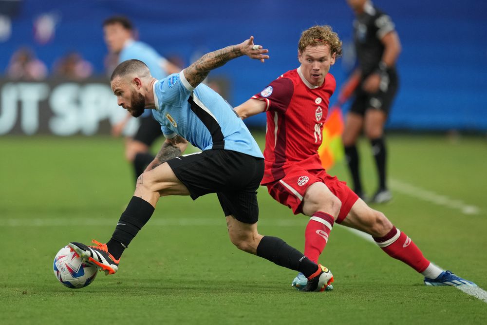 Nahitan Nández de la selección de Uruguay ante Jacob Shaffelburg de Canadá