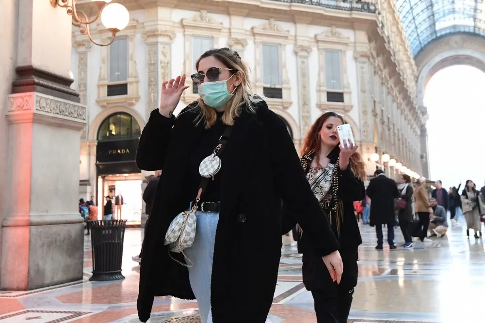 Una mujer con tapaboca camina en la galería Vittorio Emanuele II de Milan