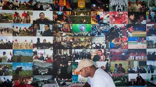 Venezuela- Un hombre usa un computador frente a fotografías en una exposición sobre Hugo Chavez