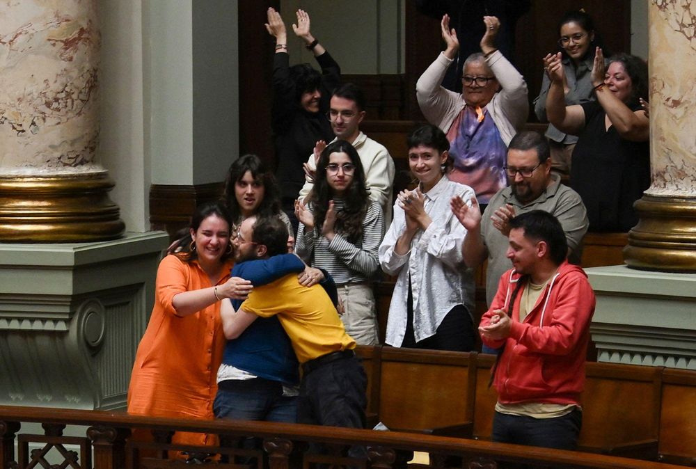 Florencia Salgueiro, vestida de color naranja, celebra junto a su madre y otros compañeros de Empatía Uruguay la aprobación de la ley de eutanasia en el Congreso uruguayo.