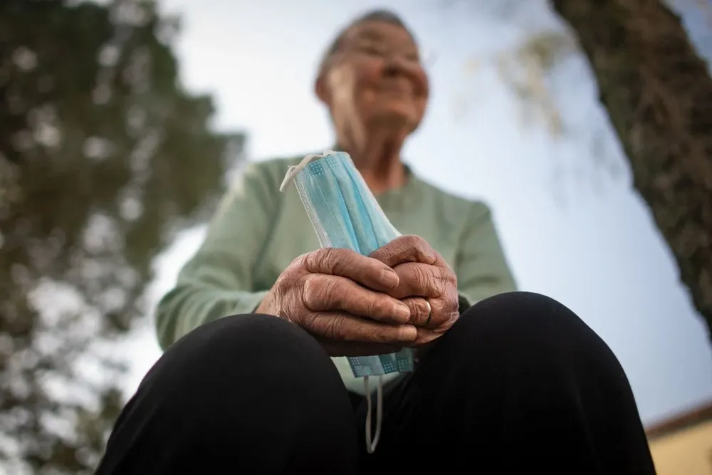 Señora sosteniendo un tapabocas