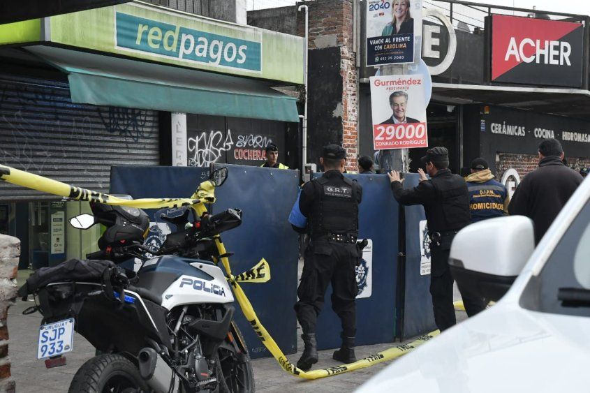 Trabajo de la Policía en la escena del crimen, afuera del local de Redpagos de la Curva de Maroñas