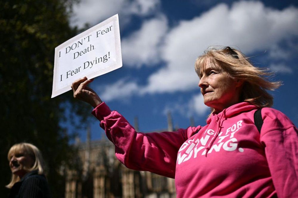 Una activista discapacitada de "Dignity in Dying" sostiene una pancarta durante una concentración a favor de las propuestas para legalizar el suicidio asistido en Reino Unido.