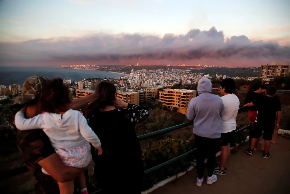Habitantes de los barrios altos de Valparaíso observan el fuego en los cerros aledaños a la vecina Viña del Mar.