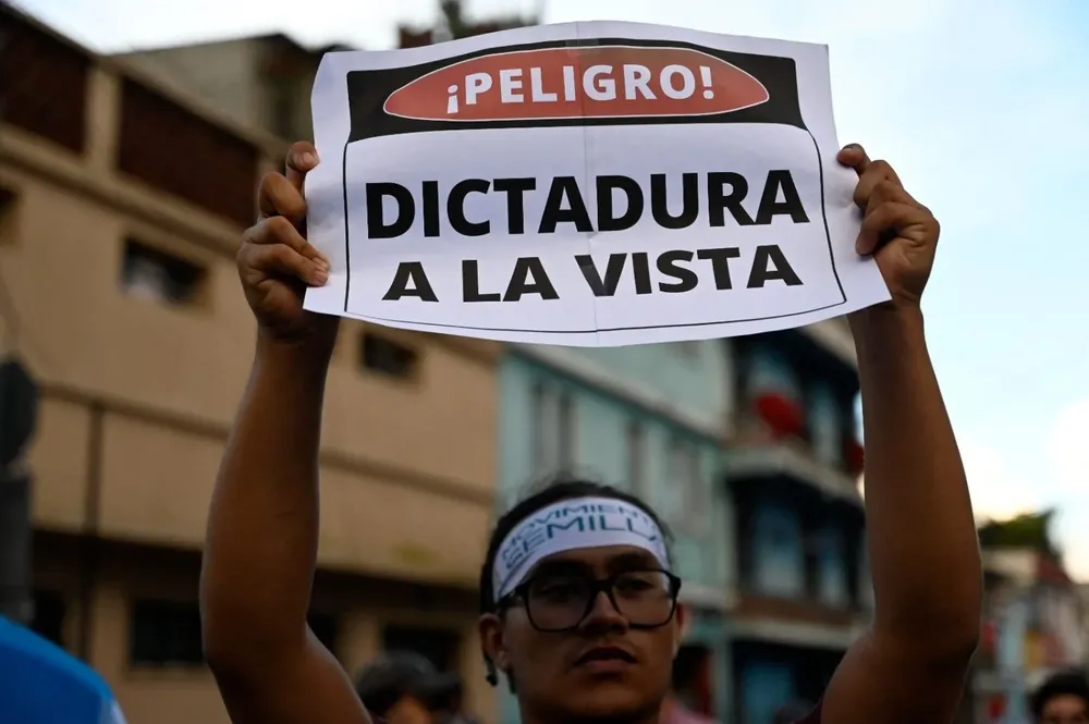 Un simpatizante del movimiento Semilla levanta un cartel alertando sobre las amenazas a la democracia