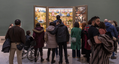 Visitantes del Museo del Prado contemplan El Jardín de las delicias, de El Bosco.