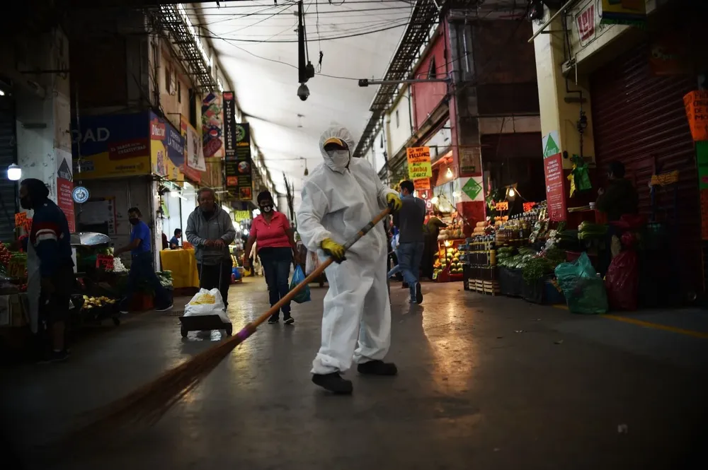 Un trabajador barre en el Mercado Central de Abastos en México