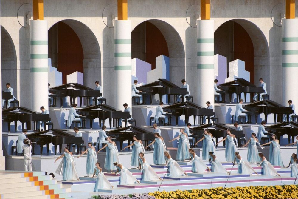 Muchos jamás sabrán quién fue pero seguramente recuerden la ceremonia de apertura de su Olimpíada en 1984, hoy para nosotros al borde de lo “kitsch”. Pero sin duda entonces glamorosa (y económica). Desplegados en escena, 84 hermosos pianos con 84 pianistas imitando el estilo Liberace. 