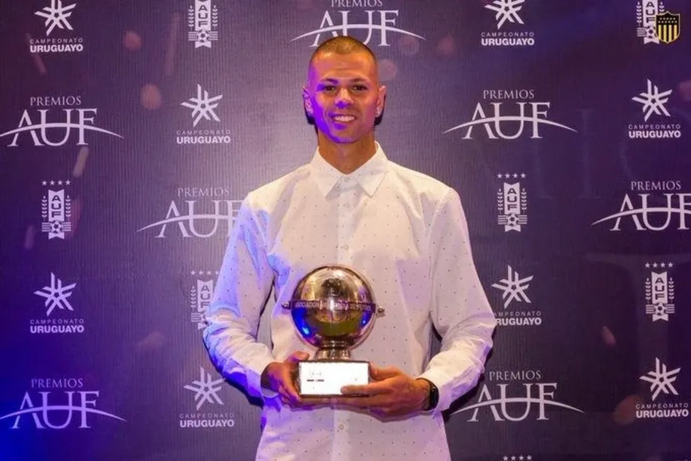 Leo Coelho con el premio que recibió de la AUF