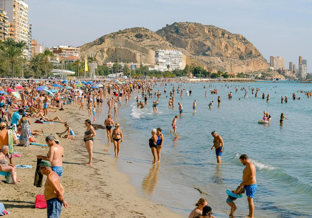 Turistas y locales disfrutan del calor en las playas de Alicante.