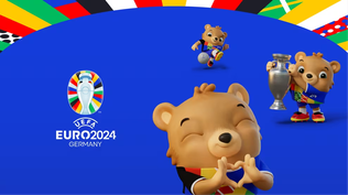 Albärt, el oso amigable y carismático, vestido con los vibrantes colores de Alemania, listo para dar la bienvenida a los equipos y aficionados al espectáculo futbolístico de la Eurocopa 2024.  