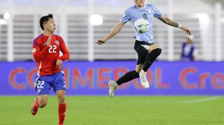 Leandro Hernández de Chile disputa un balón con Germán Barbas de Uruguay