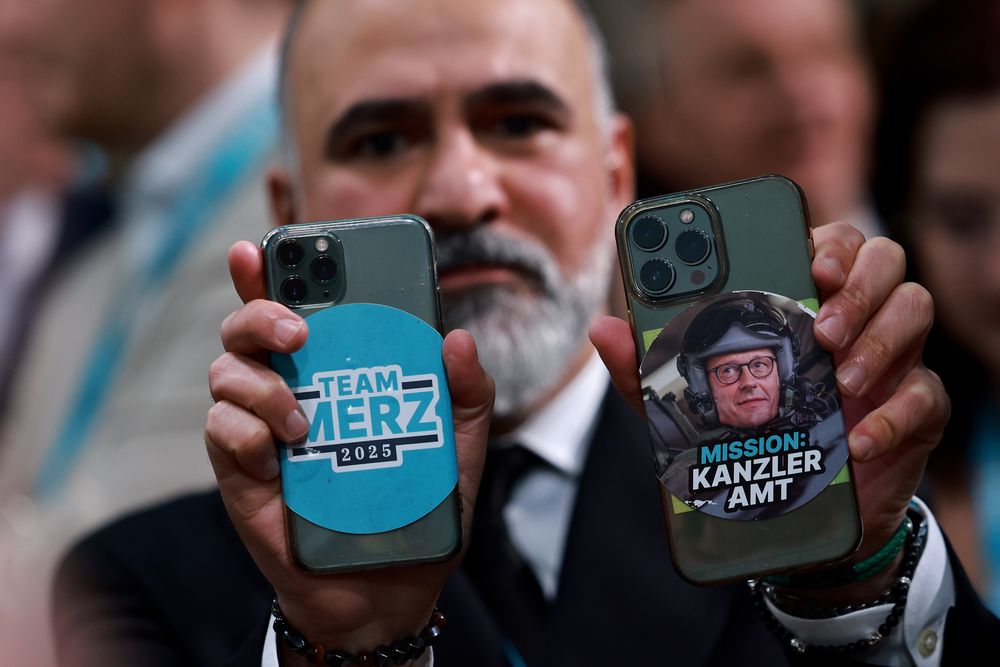 Un miembro de la CDU muestra sus teléfonos móviles con pegatinas de Merz durante el evento electoral de la Unión Demócrata Cristiana (CDU) en Berlín, Alemania.