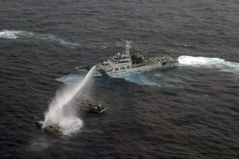 Un buque del servicio costero (dcha) que rocía con cañones de agua un barco pesquero taiwanés