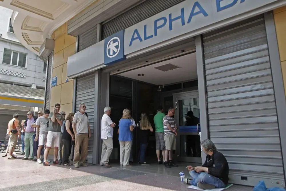 Cola para retirar dinero de un cajero automático fuera una rama de la de Grecia Alpha Bank en Atenas, Grecia.