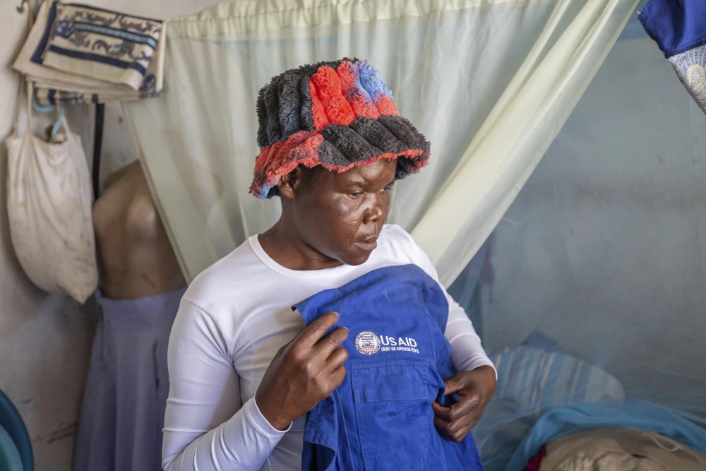 Trabajadora comunitaria de salud muestra una chaqueta de USAID que solía usar, en Harare Zimbabue.