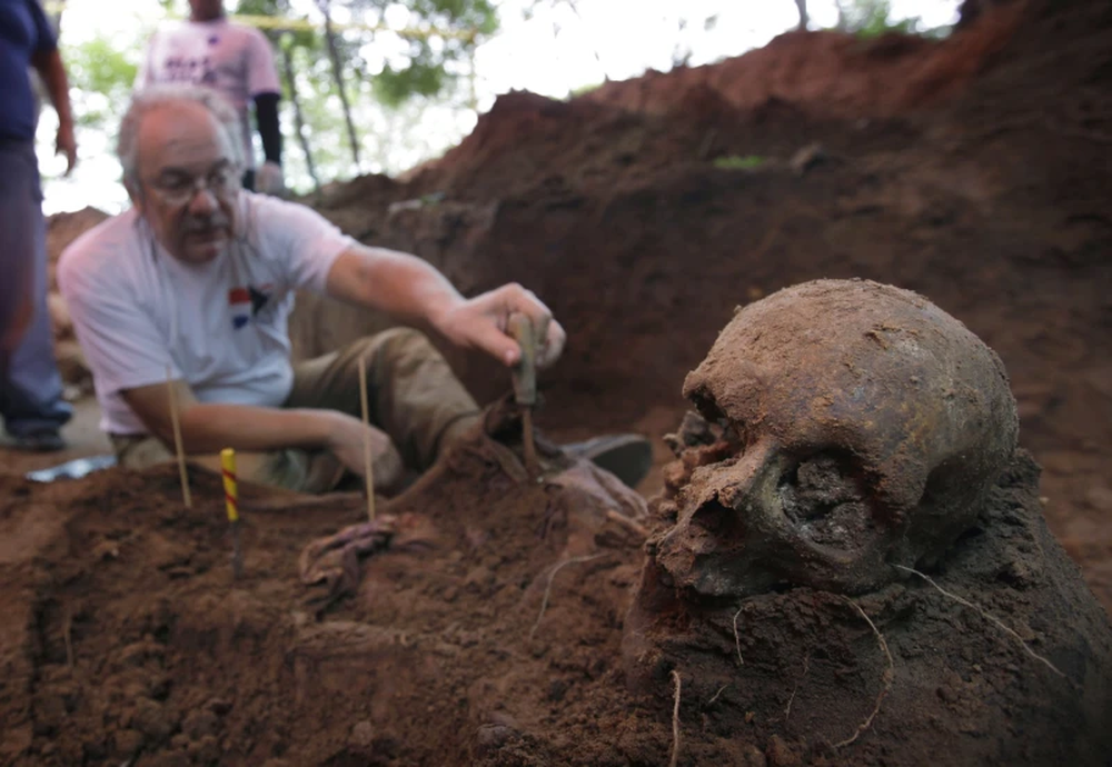 Rogelio Goiburu, integrante de la Comisión de la Verdad y Justicia de Paraguay, mira los huesos de un esqueleto encontrado en una excavación en los cuarteles de las Fuerzas Especiales de la Policía en Asunción, Paraguay, el 19 de marzo de 2013. Su padre desapareció en 1977. 