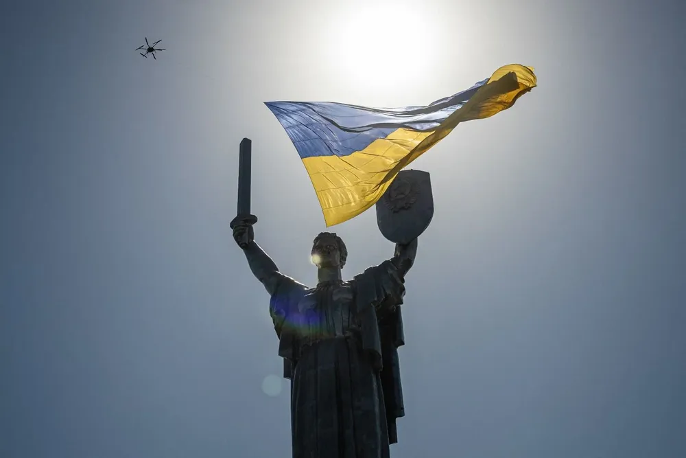 Un dron carga la bandera ucraniana, sobre el monumento a la Madre Tierra