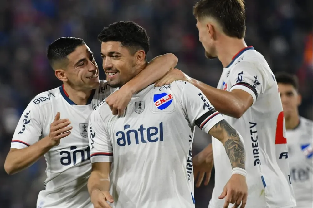 Federico Martínez celebra su gol de penal para Nacional junto a Camilo Cándido