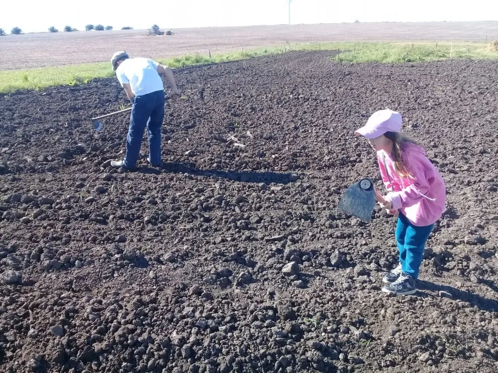Gustavo Rostagnol, joven productor rural y su sobrina Emma, quien lo acompaña de a ratos en la huerta.