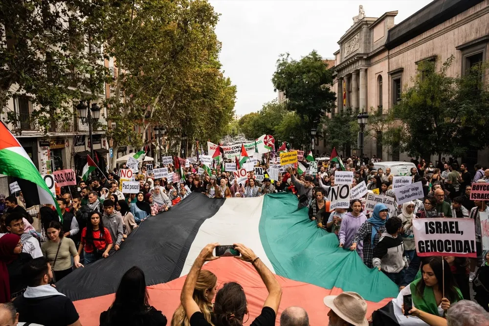 Varias personas con una bandera de Palestina durante una manifestación en apoyo al pueblo palestino.
