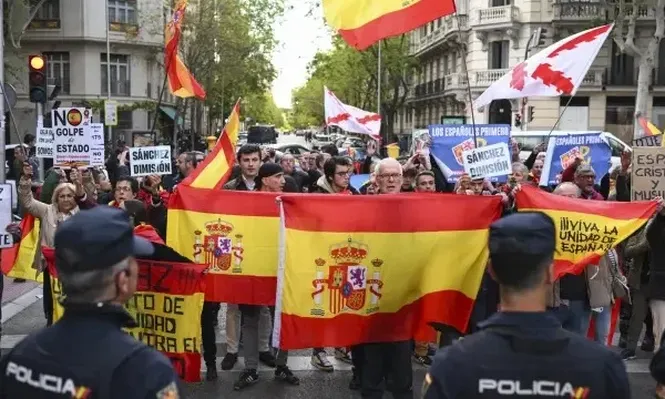 Asistentes a la manifestación para pedir la dimisión de Pedro Sánchez, este jueves en la calle de la sede del PSOE