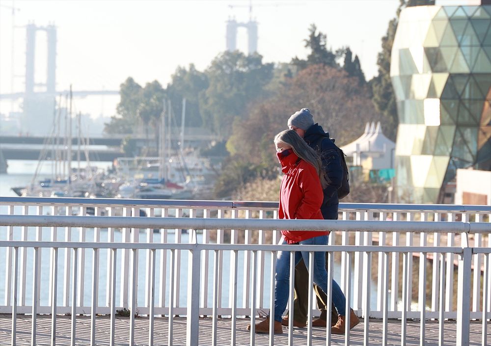 Dos personas se protegen del frío en Sevilla (Andalucía). EUROPA PRESS