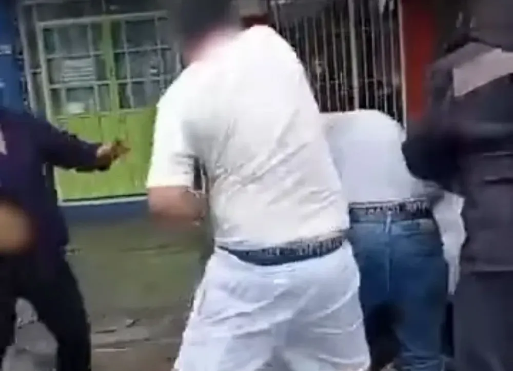 Momento en el que uno de los heridos es golpeado por varias personas en la calle