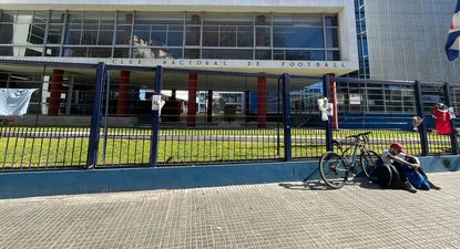 Un hincha de Nacional recostado contra un muro de la sede del club, homenajeando a Juan Izquierdo