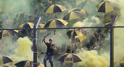 Hinchas de Peñarol colgados al tejido, humo y paraguas abiertos: las razones por las que el partido demoró 16 minutos en comenzar