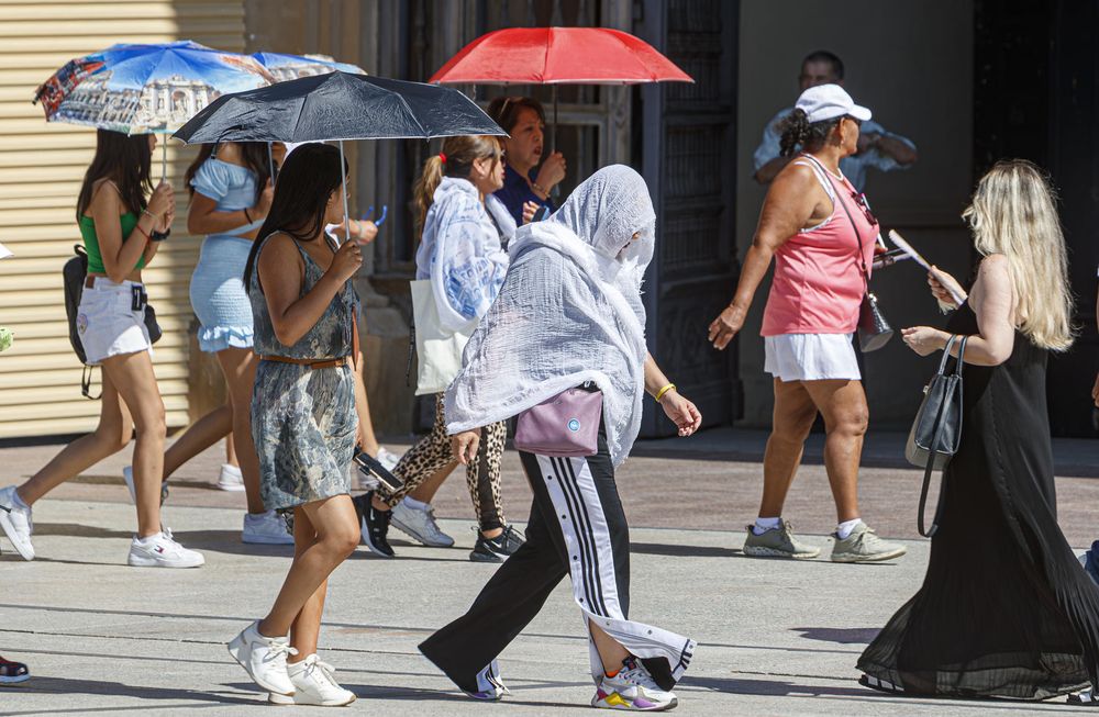 Varios turistas en la Plaza de El Pilar de Zaragoza, con temperaturas que pueden llegar a 41 grados este domingo. EFE