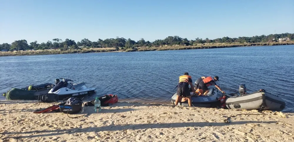 Hay dos gomones, una moto de agua y un equipo de buceo trabajando en la búsqueda