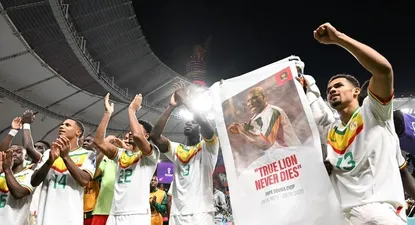 Los jugadores senegaleses celebran su clasificación a octavos de final del Mundial Qatar 2022 con la imagen de Papa Bouba Diop