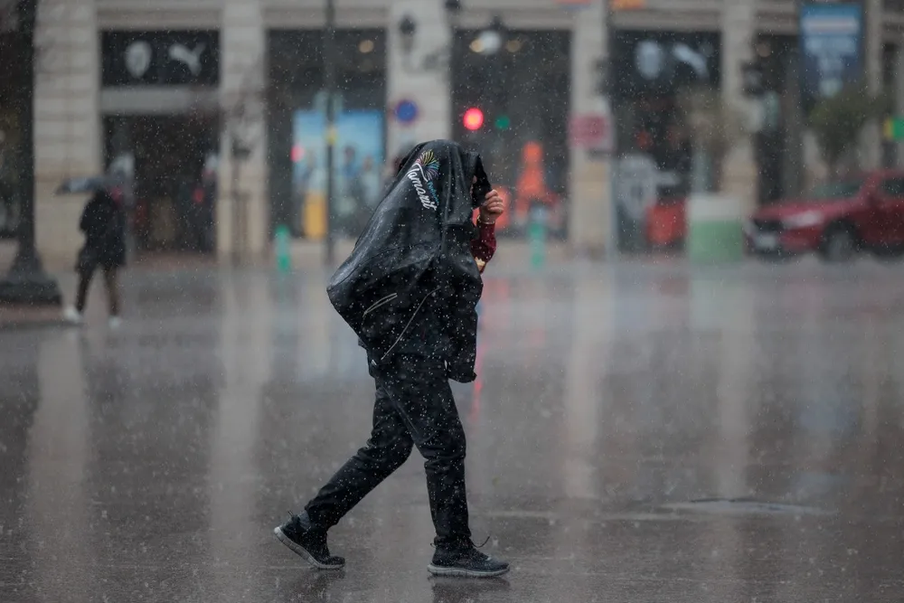Un hombre camina bajo la lluvia en Valencia.