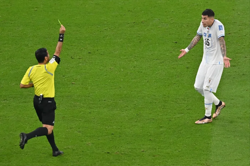 Alireza Faghani amonesta a Mathías Olivera en el partido vs Portugal.