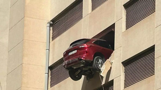 Un coche queda suspendido en la tercera planta de un edificio de aparcamientos.