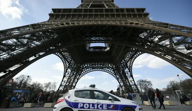 Un coche de policía estacionado frente a la torre Eiffel, en Francia, Paris