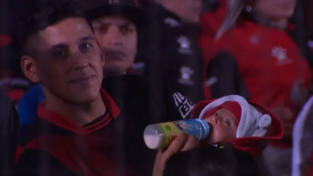 Hincha de Colón alimentando a su hijo en la tribuna