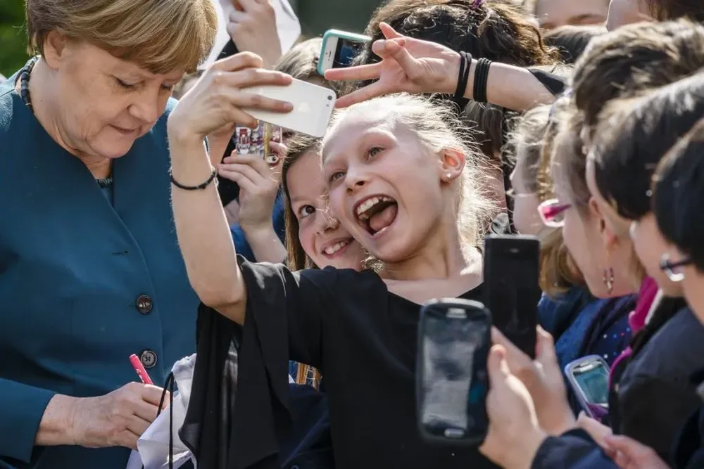 Angela Merkel junto a pequeñas fanáticas