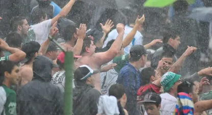 Hinchas de Racing alientan al equipo bajo la lluvia.