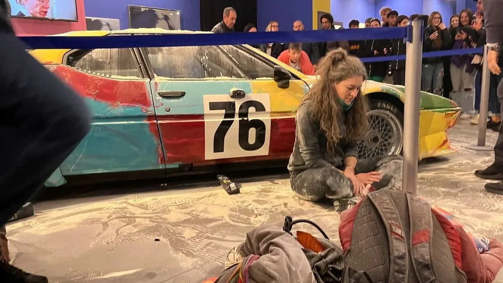 Una de las activistas junto a un autoBMW M1 pintado en 1979 por Andy Warhol bañado en harina.