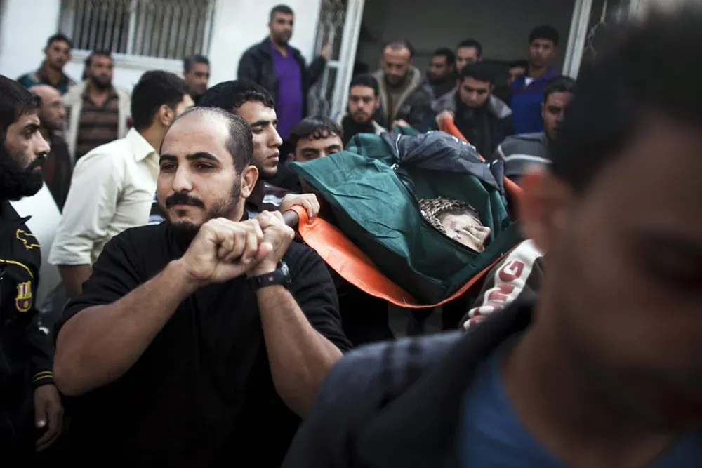 Amigos y familiares llevan el cuerpo de Anwar Hadi Quadi, fallecido cerca de la verja anterior a la zona de aislamiento con Israel.