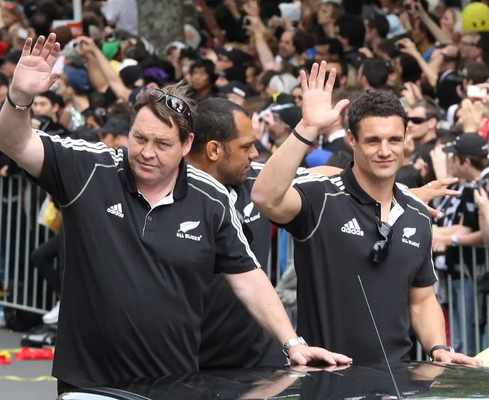 El jugador de Nueva Zelanda Dan Carter y el asistente del entrenador, Steve Hansen, participan en el desfile para celebrar la victoria de la Copa Mundial de Rugby en Auckland