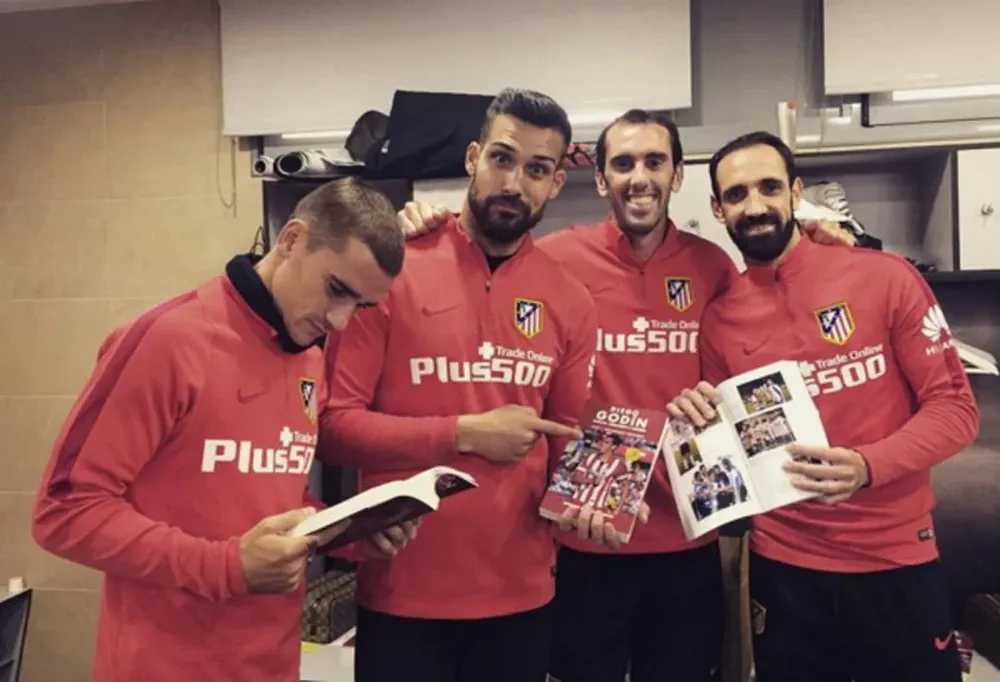 Godín y sus compañeros con el libro del uruguayo
