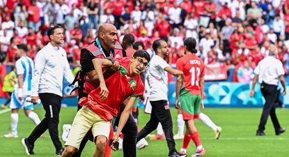 Un miembro de la seguridad detiene a uno de los hinchas de Marruecos que invadió la cancha &nbsp;